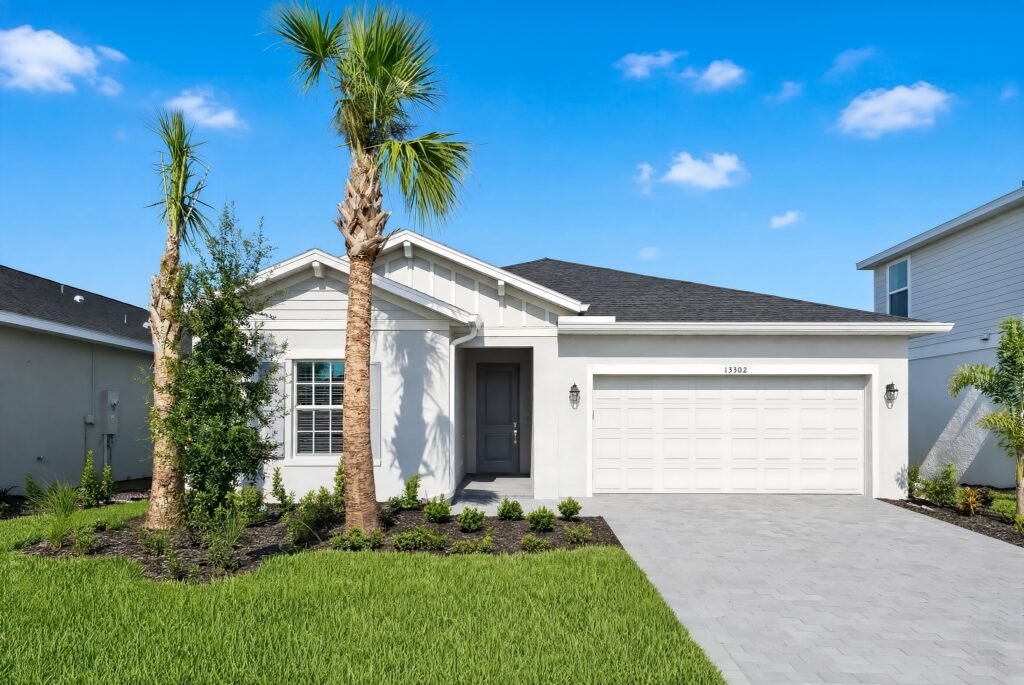 Photograph of a completed single-storey Bartik home at Turnleaf in Punta Gorda, seen from the street with young palms in the front garden and neighbouring houses either side.